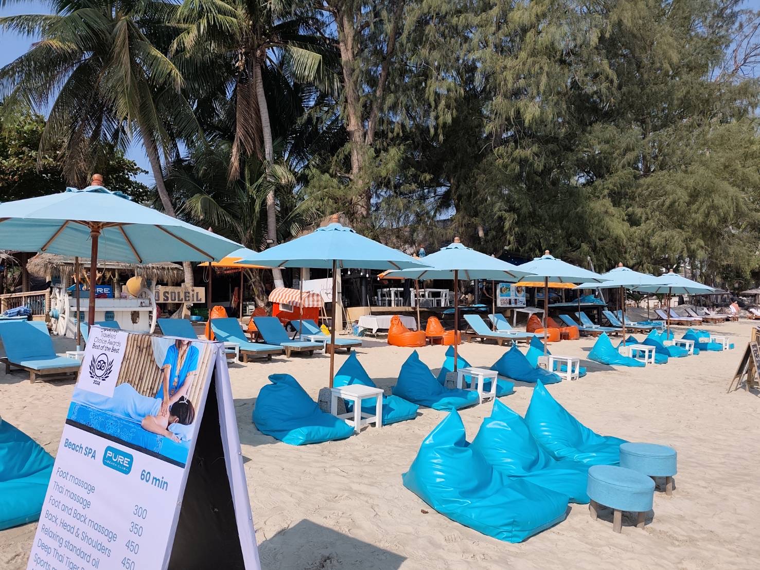 Blue beanbags, sunbeds and umbrellas — the full daytime setup on Choeng Mon Beach