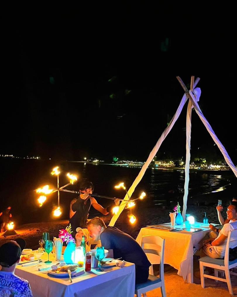Fire spinner performing beside the tent tables — guests watch from their seats