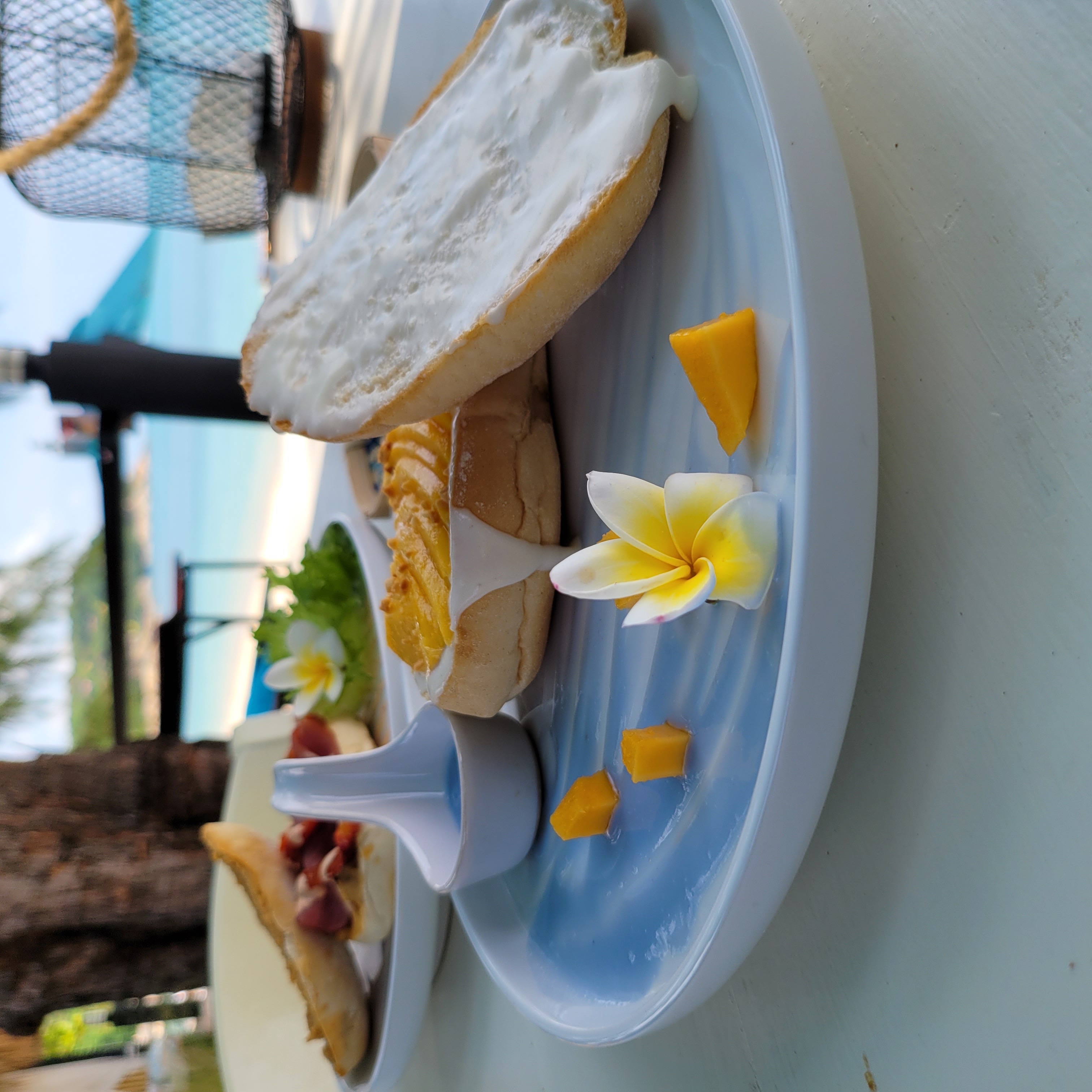 Mango cream cheese bagel served at the table — with the ocean as your backdrop