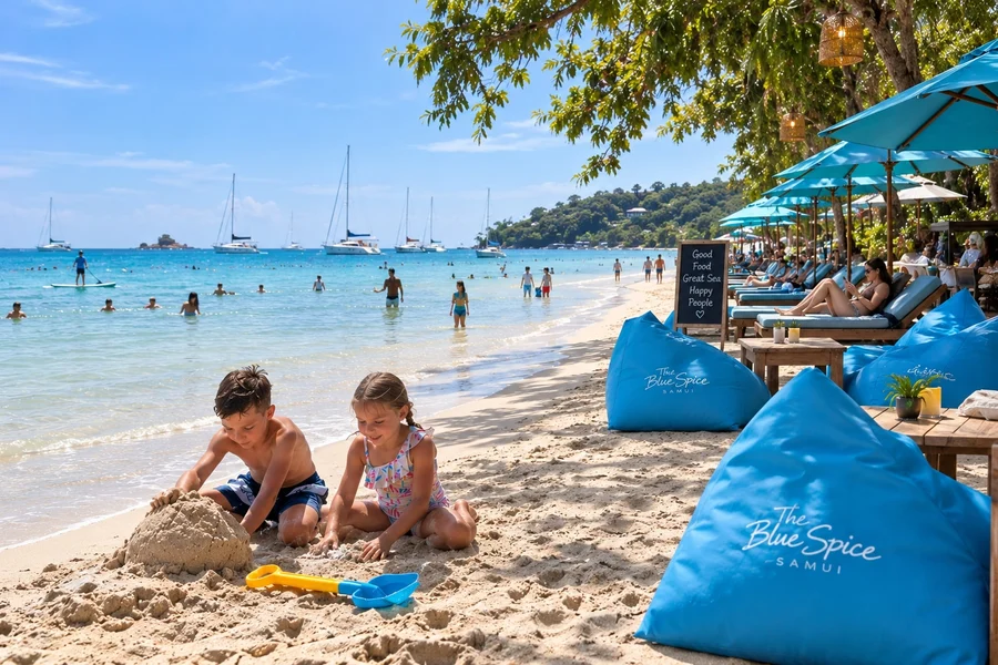 Children building a sandcastle beside blue beanbags at The Blue Spice